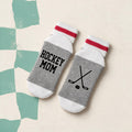 Bas de laine gris et rouge avec batons de hockey croises illustres et le message Hockey mom, boutique Sans Filtre