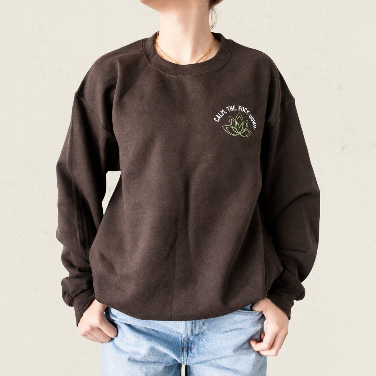 Chandail crewneck brun chocolat avec fleur de lotus illustree et le message Calm the fuck down, boutique Sans Filtre