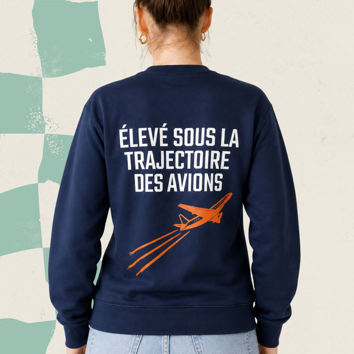 Dos d'un chandail crewneck bleu marine avec avion orange illustre et le message Eleve sous la trajectoire des avions, boutique Sans Filtre