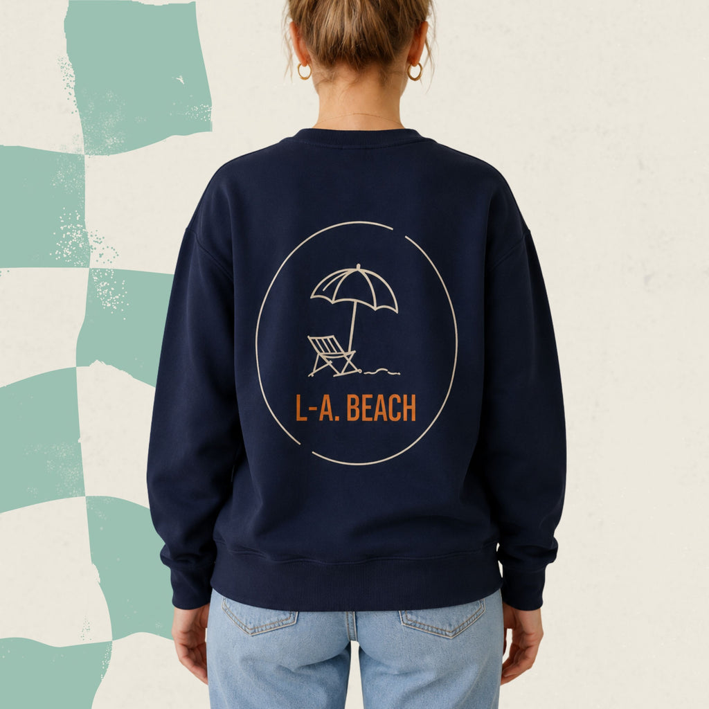 Dos d'un chandail crewneck bleu marine avec parasol et chaise longue illustres et le logo L.-A. Beach, boutique Sans Filtre