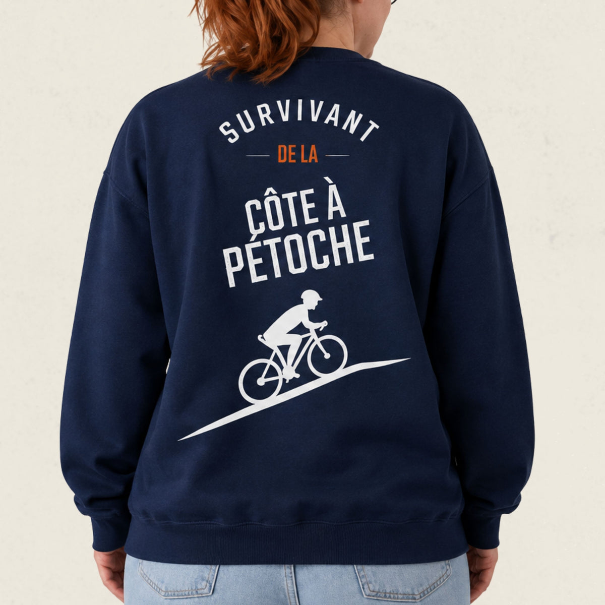 Dos d'un chandail crewneck bleu marine avec cycliste illustre et le message Survivant de la cote a Petoche, boutique Sans Filtre