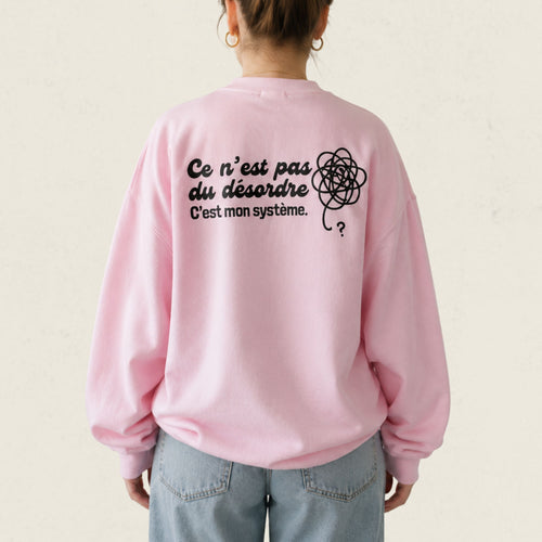 Dos d'un chandail crewneck rose avec gribouillis illustre et le message Ce n'est pas du desordre, c'est mon systeme, boutique Sans Filtre