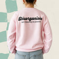 Dos d'un chandail crewneck rose avec le message Desorganisee avec beaucoup de potentiel, boutique Sans Filtre
