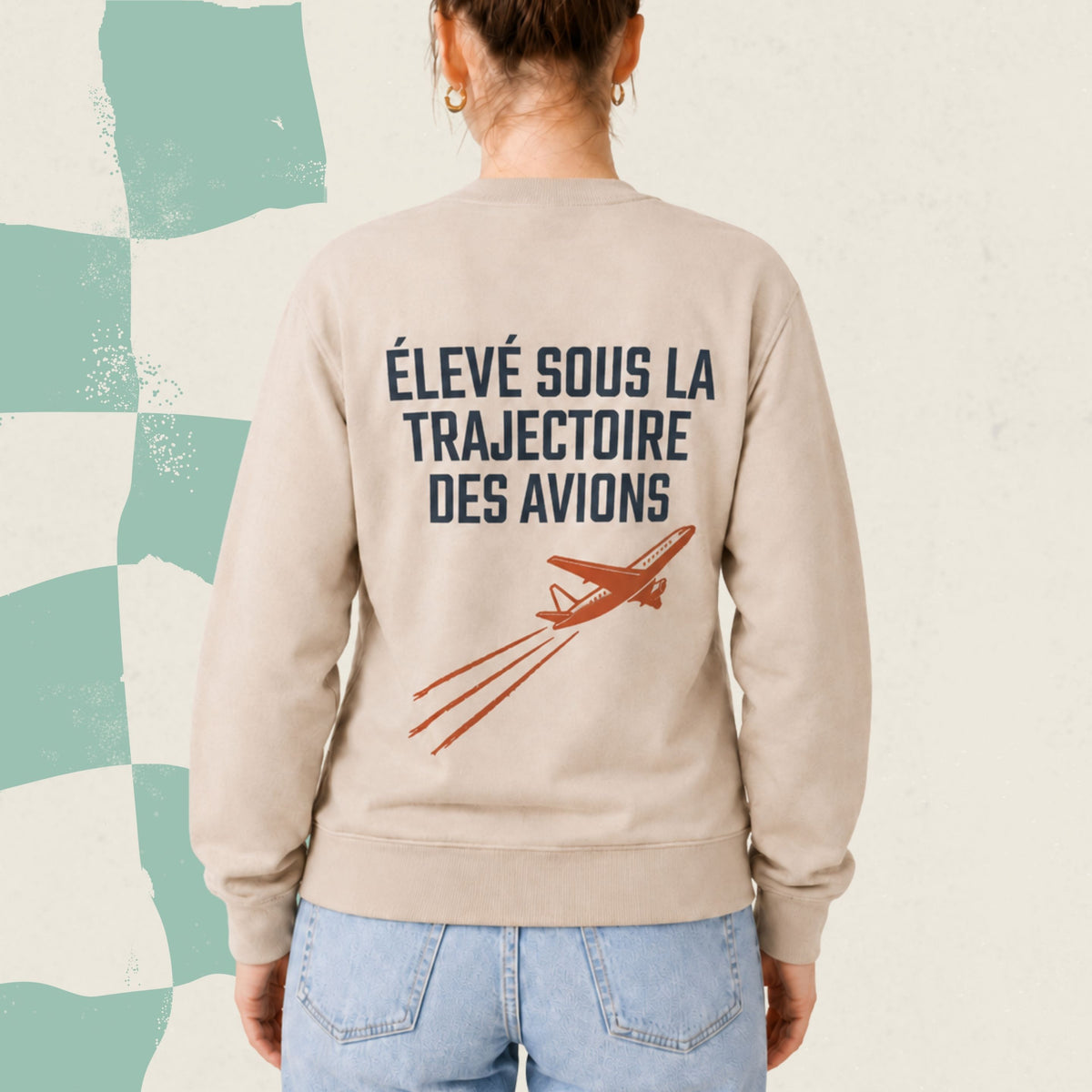 Dos d'un chandail crewneck sable avec avion illustre et le message Eleve sous la trajectoire des avions, boutique Sans Filtre