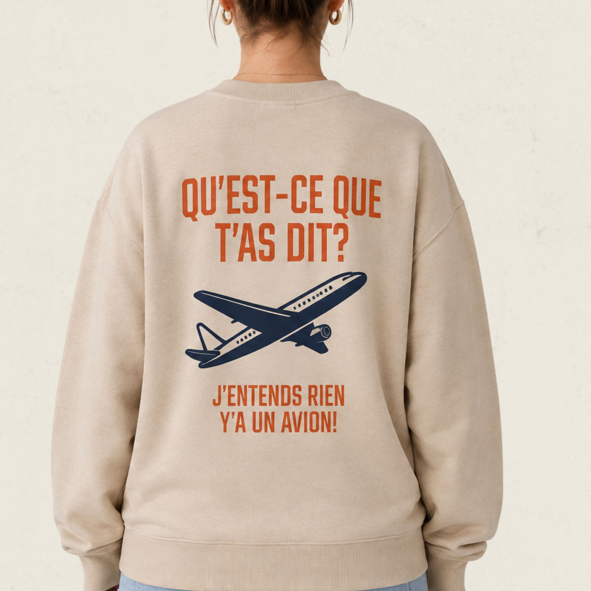 Dos d'un chandail crewneck sable avec avion illustre et le message Qu'est-ce que t'as dit j'entends rien y'a un avion, boutique Sans Filtre