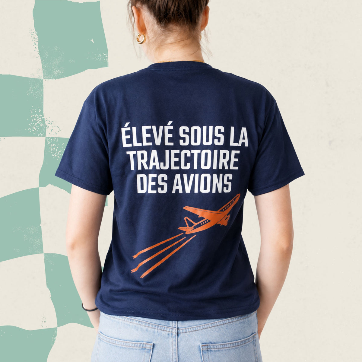 Dos d'un t-shirt bleu marine avec avion orange illustre et le message Eleve sous la trajectoire des avions, boutique Sans Filtre