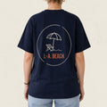 Dos d'un t-shirt bleu marine avec parasol et chaise longue illustres et le logo L.-A. Beach, boutique Sans Filtre