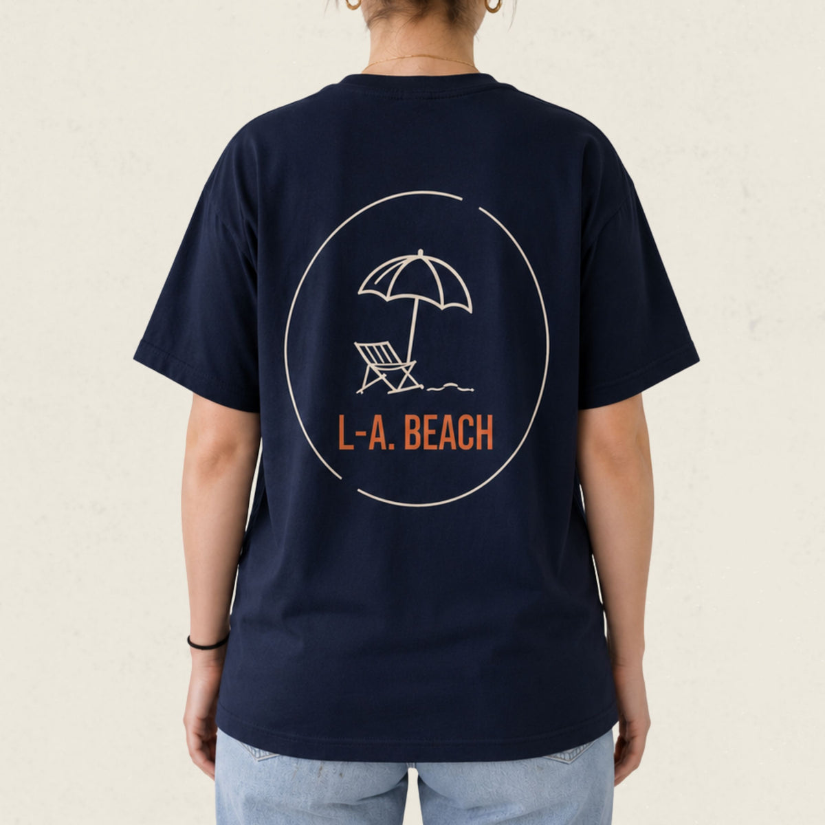 Dos d'un t-shirt bleu marine avec parasol et chaise longue illustres et le logo L.-A. Beach, boutique Sans Filtre