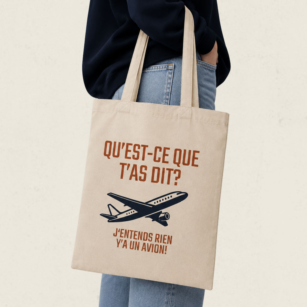 Sac fourre-tout ecru avec avion illustre et le message Qu'est-ce que t'as dit j'entends rien y'a un avion, boutique Sans Filtre