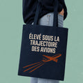 Sac fourre-tout bleu marine avec avion illustre et le message Eleve sous la trajectoire des avions, boutique Sans Filtre