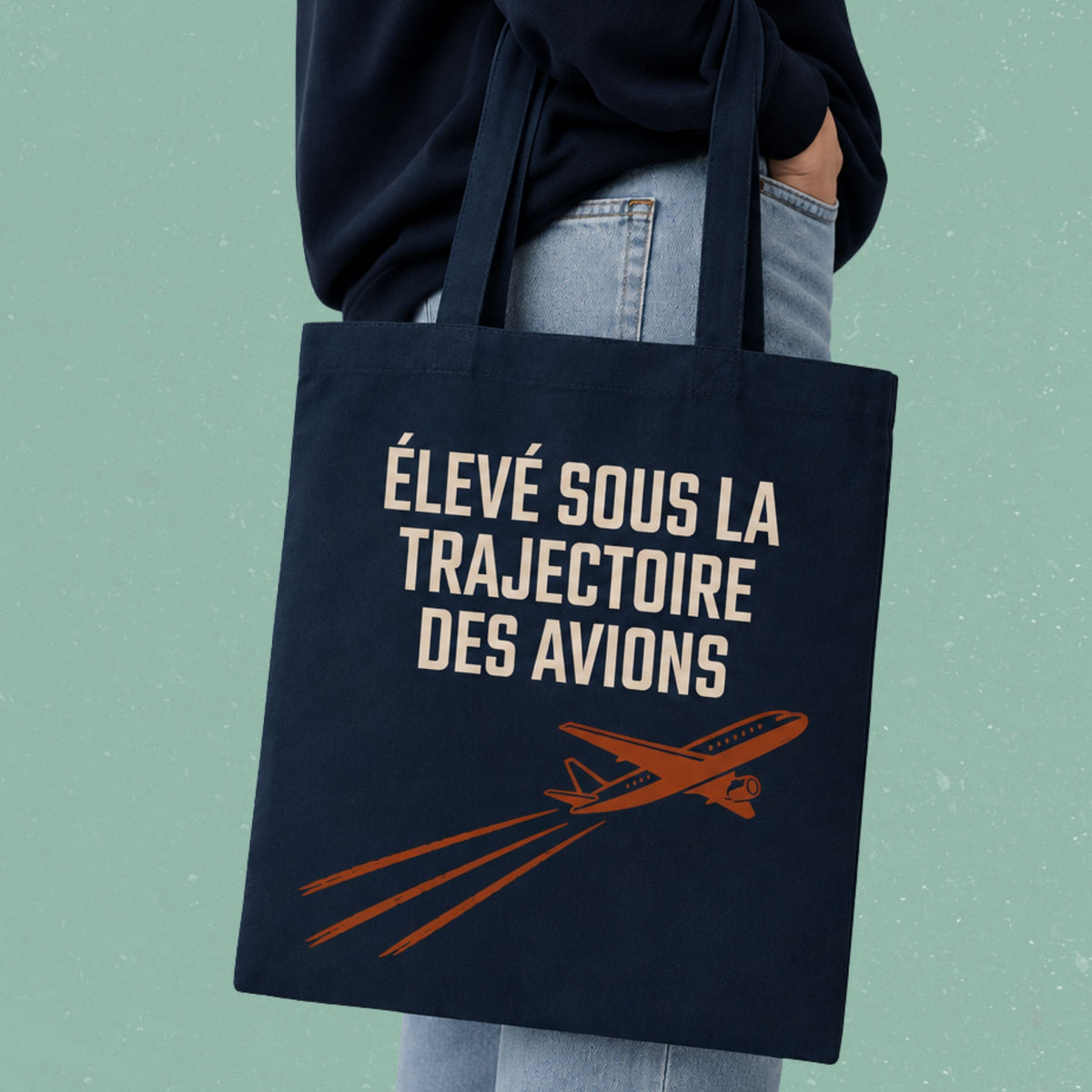 Sac fourre-tout bleu marine avec avion illustre et le message Eleve sous la trajectoire des avions, boutique Sans Filtre