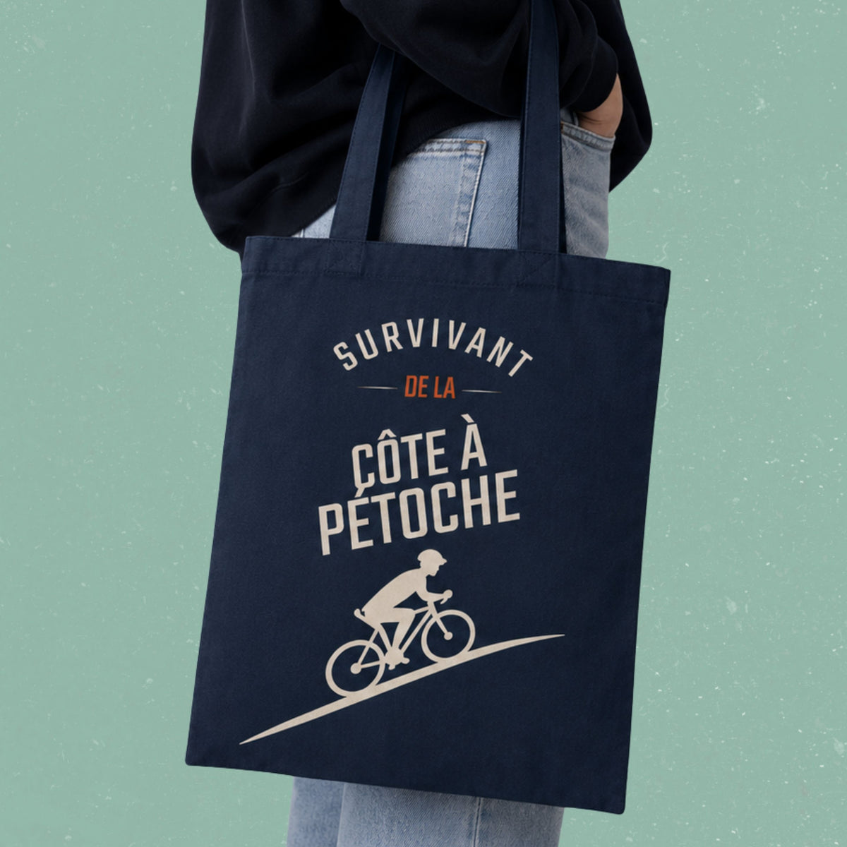 Sac fourre-tout bleu marine avec cycliste illustre et le message Survivant de la cote a Petoche, boutique Sans Filtre
